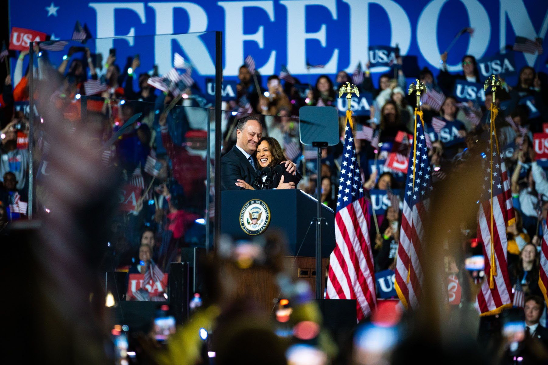 Vice President Kamala Harris and her husband, Doug Emhoff, hug on stage following a speech at the Ellipse in Washington, D.C.