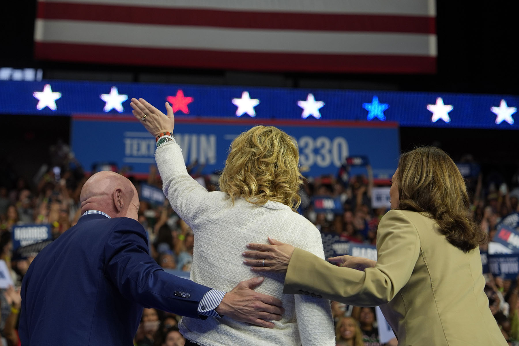 Vice President Kamala Harris stands on stage with Sen. Mark Kelly and his wife former Rep. Gabby Giffords at a rally in Glendale, Arizona.