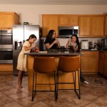 Jasmine Lopez and her two daughters standing in their kitchen, making boba tea together.