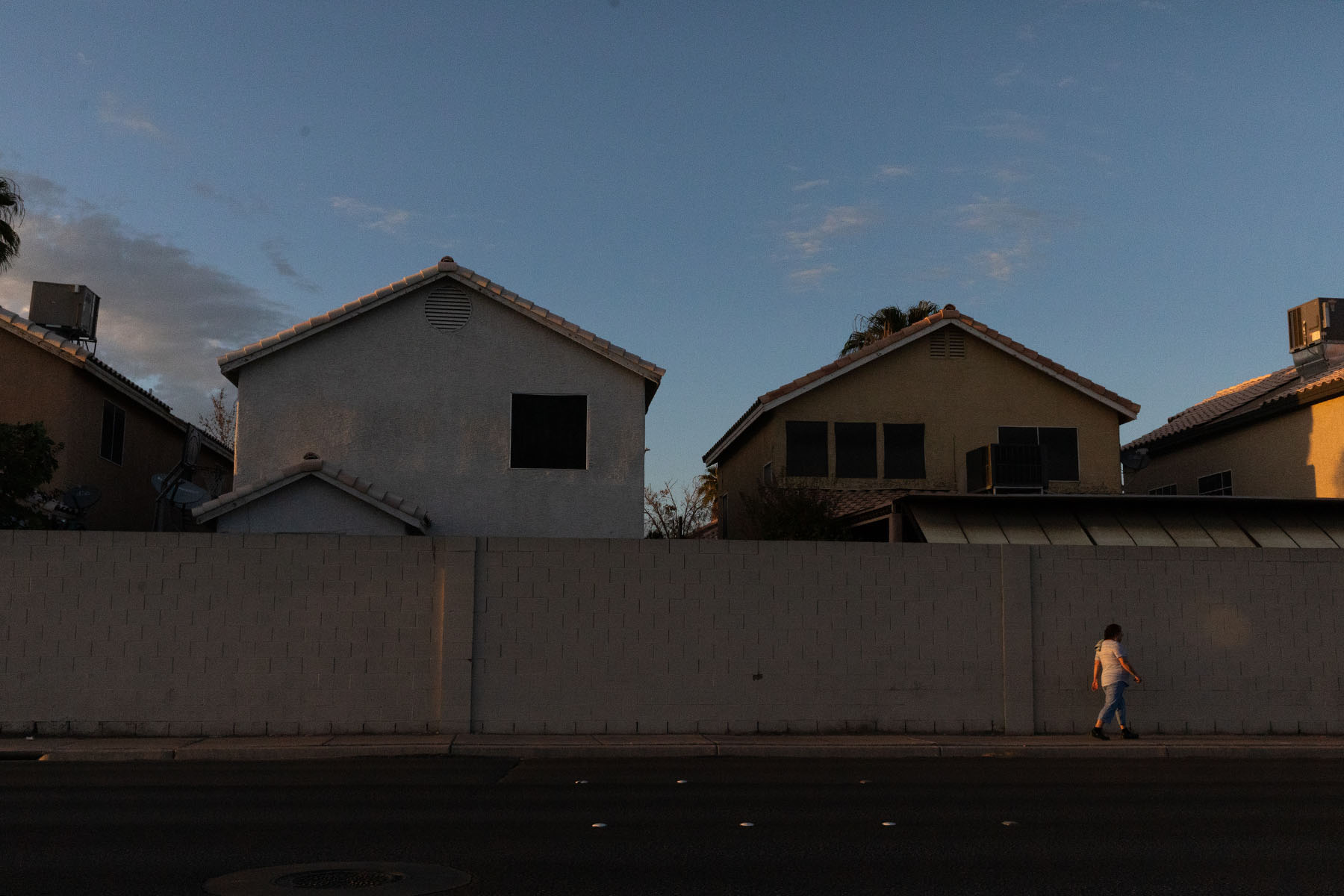 Residential houses in Sunrise Manor, North Las Vegas, with a person walking along the sidewalk.