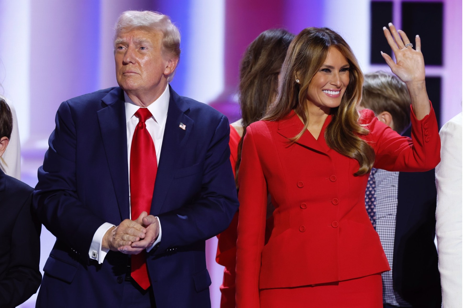 Melania Trump waves to the crowd, standing next to Donald Trump