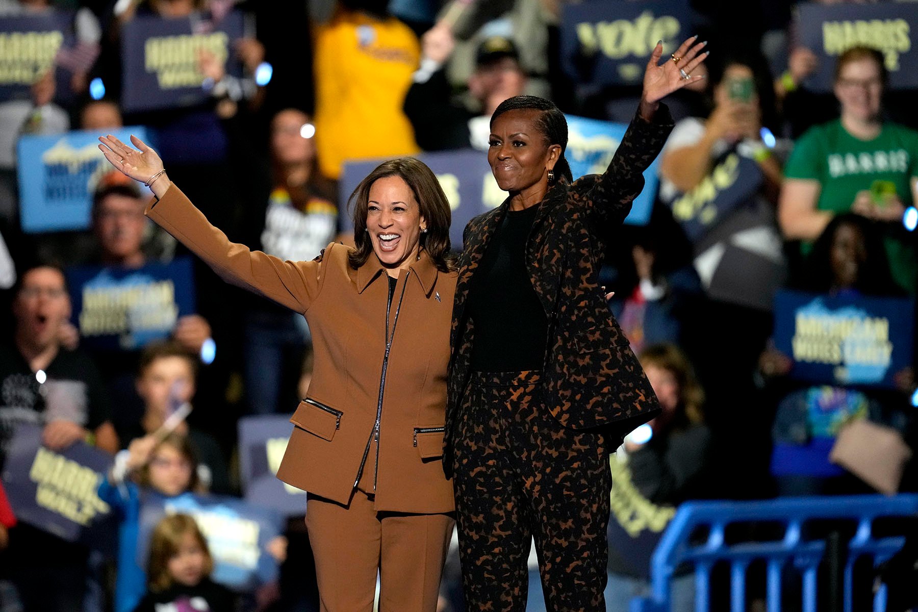 La vicepresidenta Harris y la ex primera dama Michelle Obama saludan a sus seguidores desde el escenario en un mitin de campaña en Kalamazoo, Michigan.