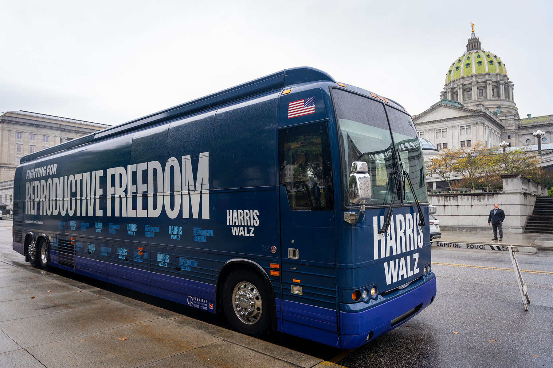 A blue Harris-Walz campaign bus with the slogan 'Fighting for Reproductive Freedom' painted on is parked outside the Pennsylvania State Capitol in Harrisburg.