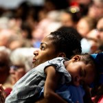 A child sleeps on their mother's shoulder at a Kamala Harris rally in Wisconsin.