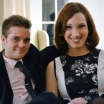 Sarah McBride and Andy Cray sit together smiling as they pose for a photo.