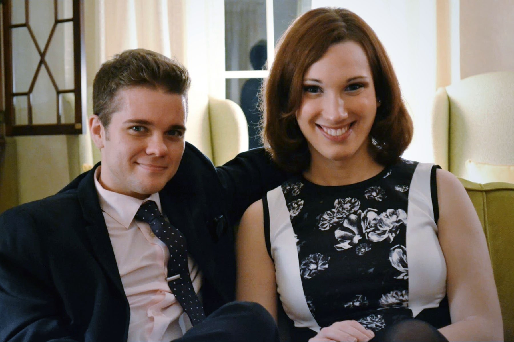 Sarah McBride and Andy Cray sit together smiling as they pose for a photo.