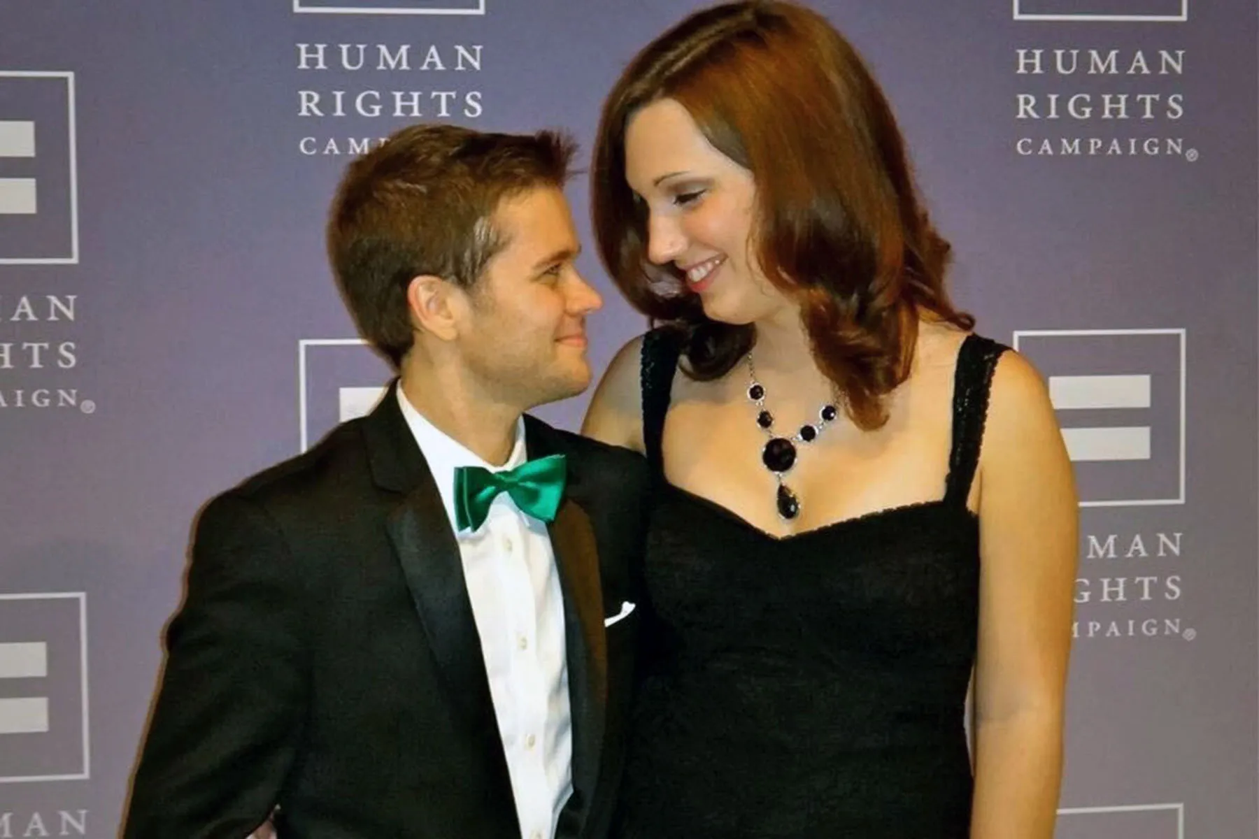 Sarah McBride and her husband Andy Cray smile at each other as they pose for a photo at a Human Rights campaign event.