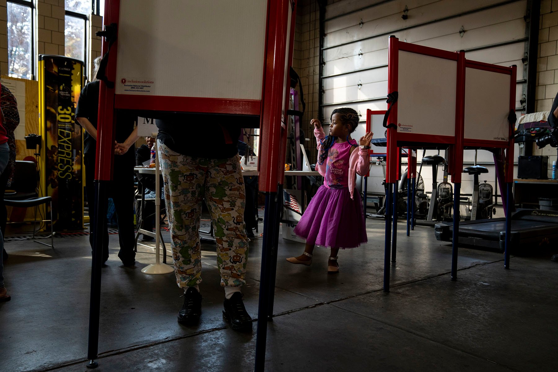 A voter fills out her ballot at a fire station while her daughter waits for her in Louisville, Kentucky.