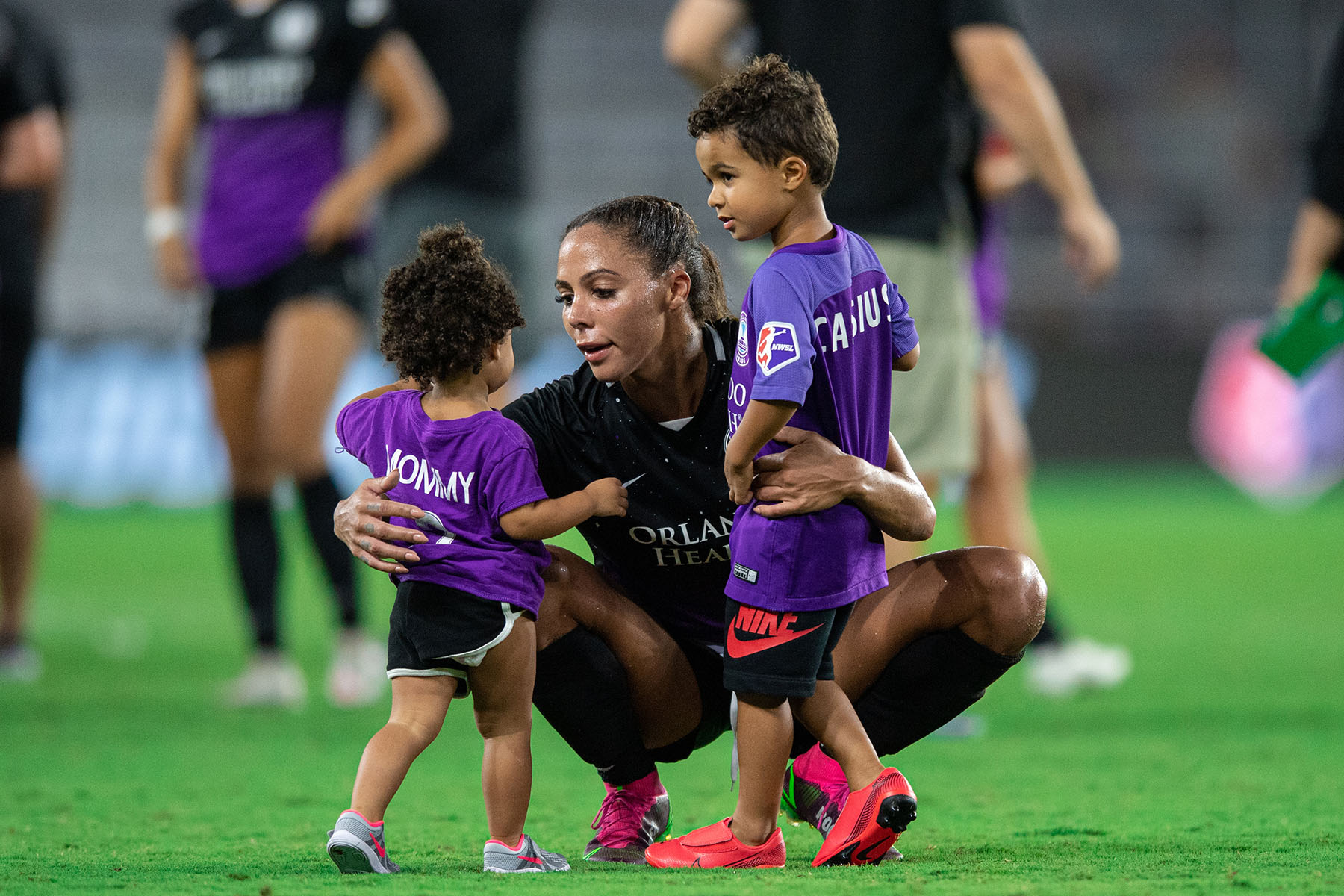 Sydney Leroux greets her two children on the field after a game in Orlando, Florida.