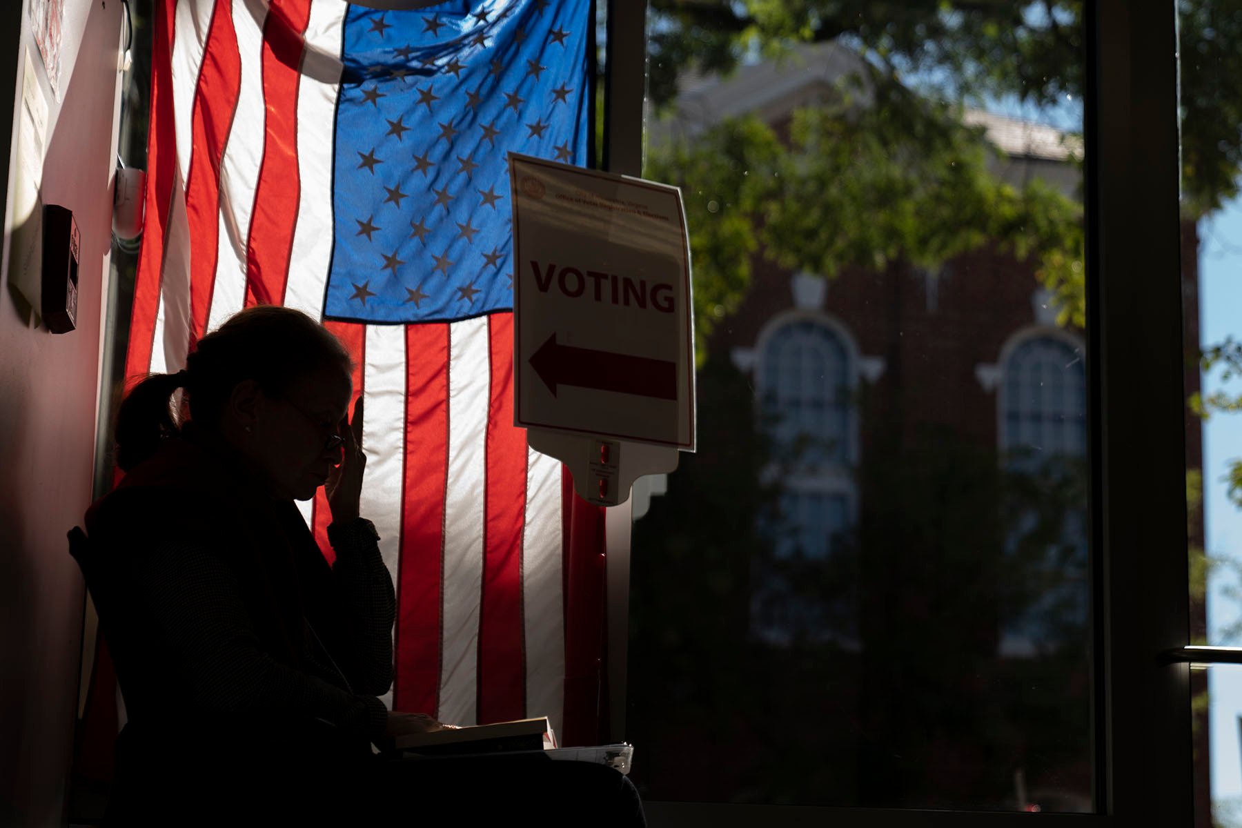 Un trabajador electoral espera para saludar a los votantes anticipados en Alexandria, Virginia.