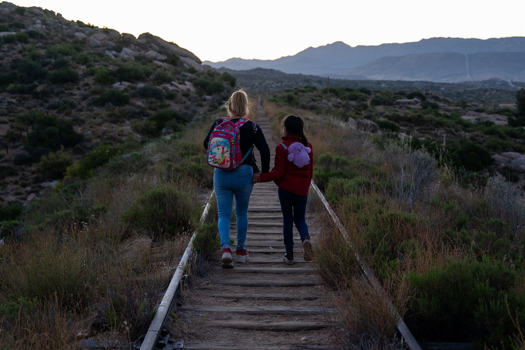 Een vrouw en een jong meisje lopen door een verlaten spoorlijn in Jacumba Hot Springs, San Diego, Californië