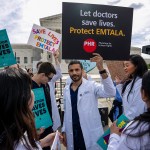 A group of doctors joins abortion rights supporters at a rally outside the Supreme Court. One holds a sign that reads 