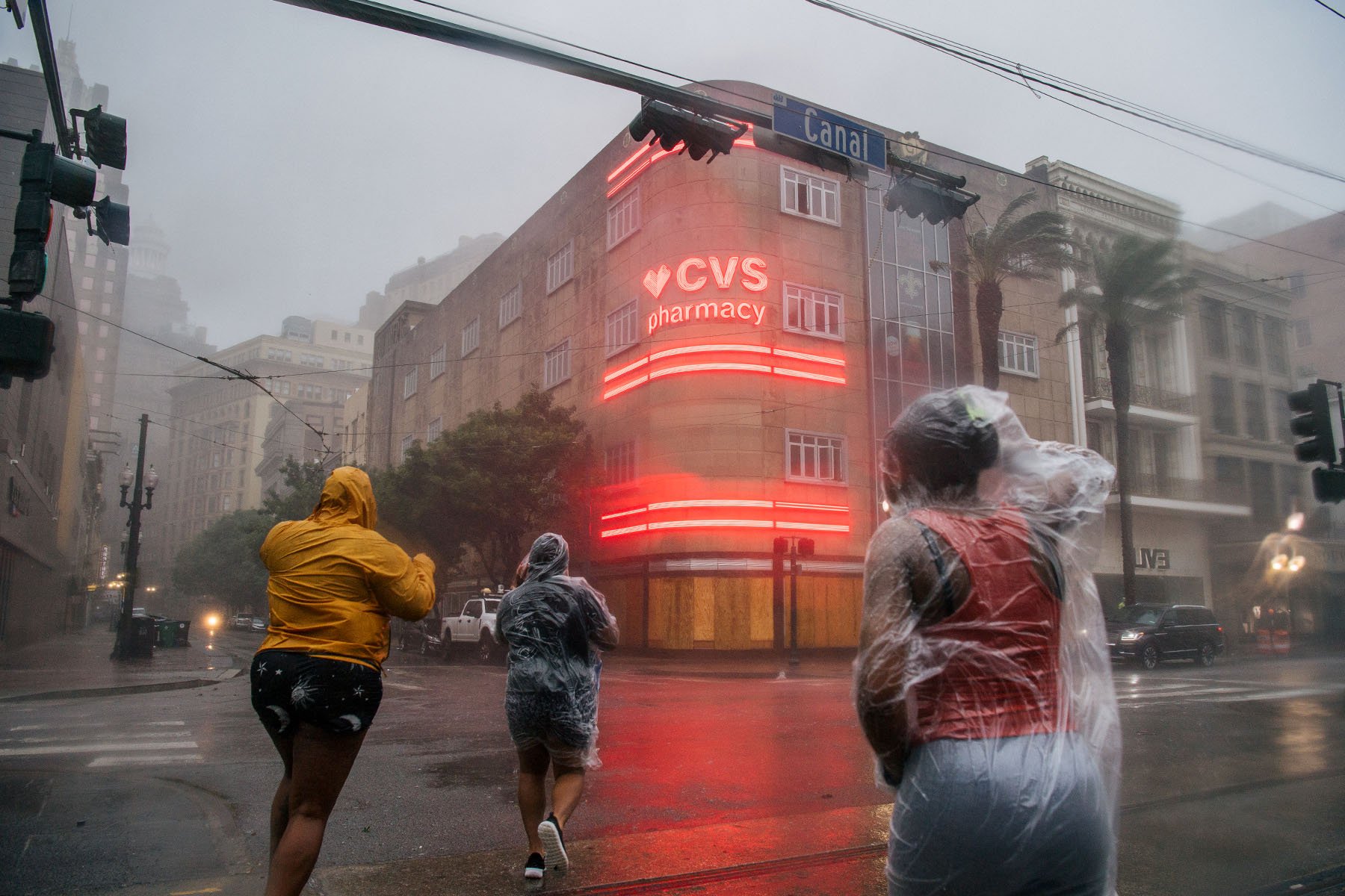 A group of people cross an intersection in New Orleans, Louisiana, during Hurricane Ida.