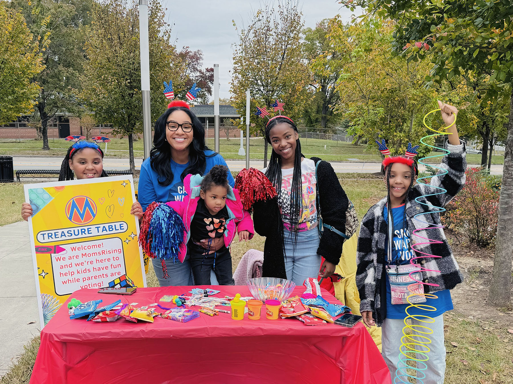 Kids and moms pose at a table full of of toys and activities in North Carolina.