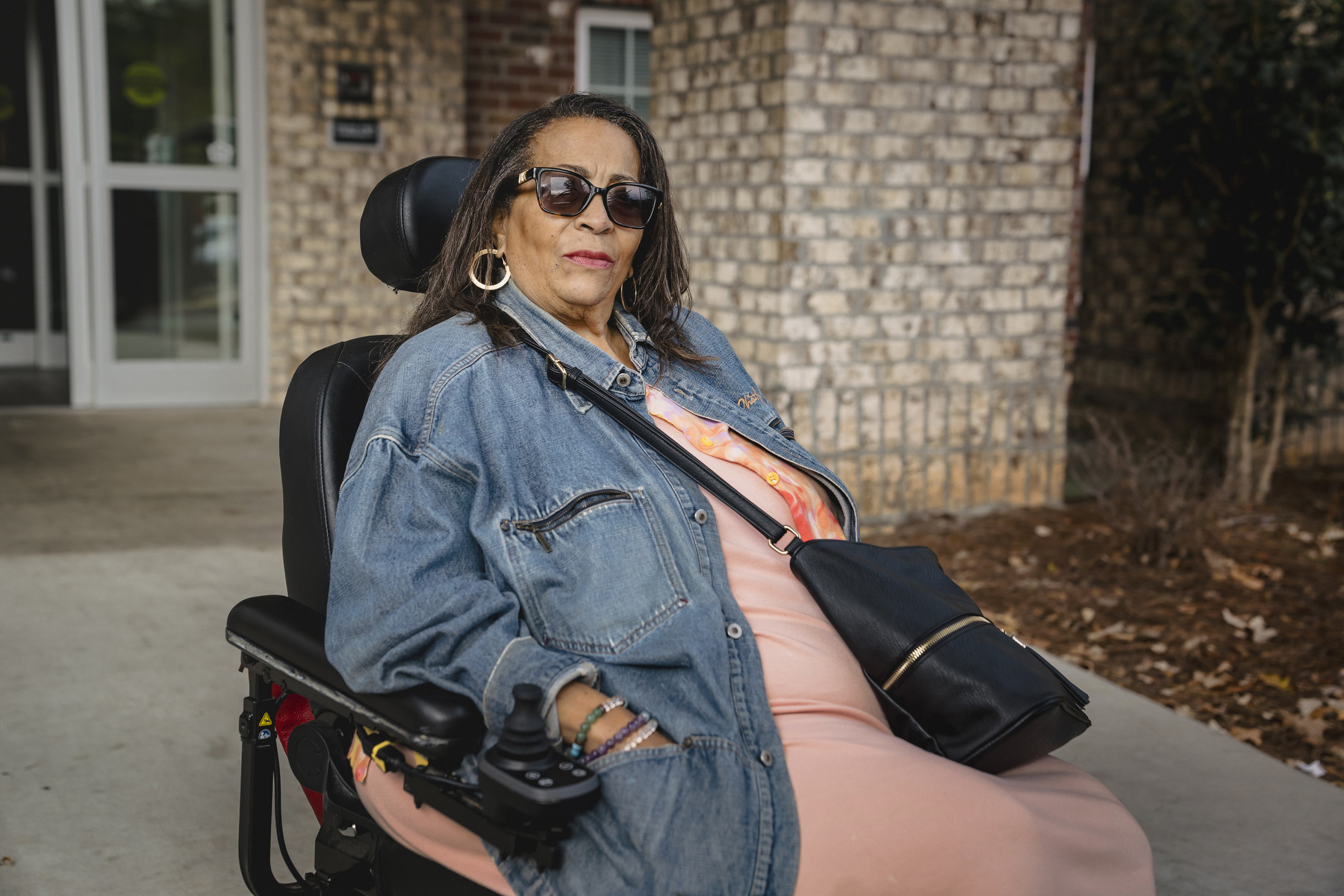 A woman sits in a wheelchair looking at the camera.