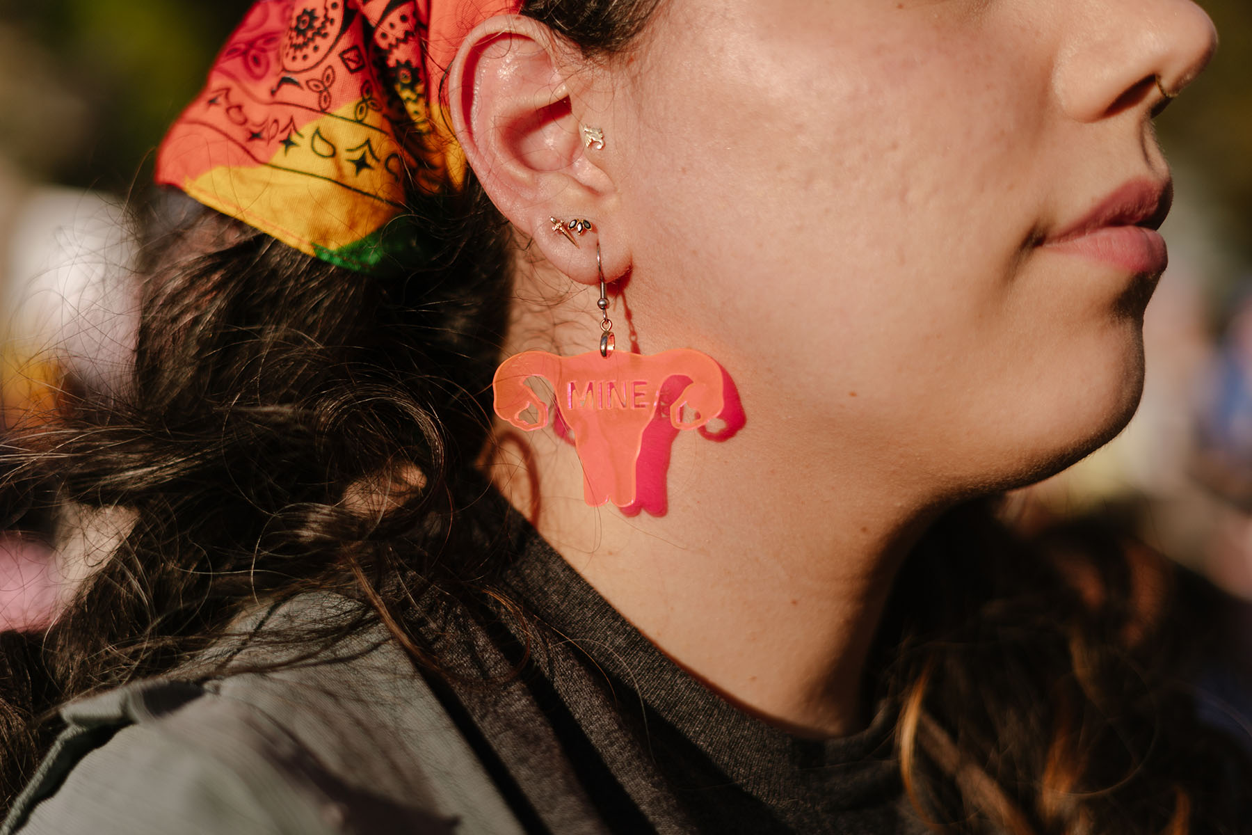 Details of a woman wearing earrings in the shape of ovaries at the "We Won't Go Back" Women's March in Washington, D.C.