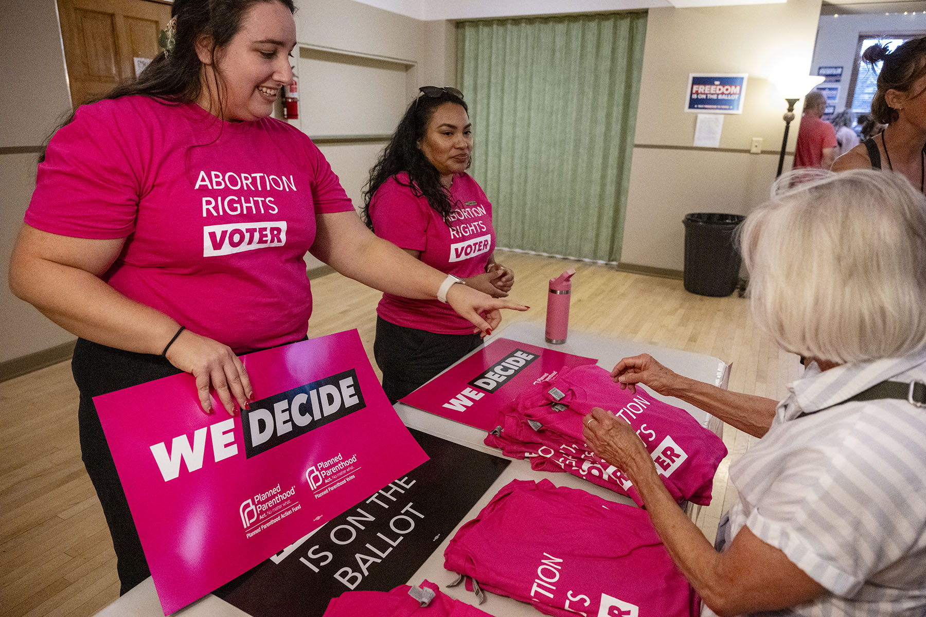 Rally-goers handle signs and shirts displaying abortion rights slogans before a rally.