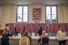 A voter passes by a table of four seated female poll workers.