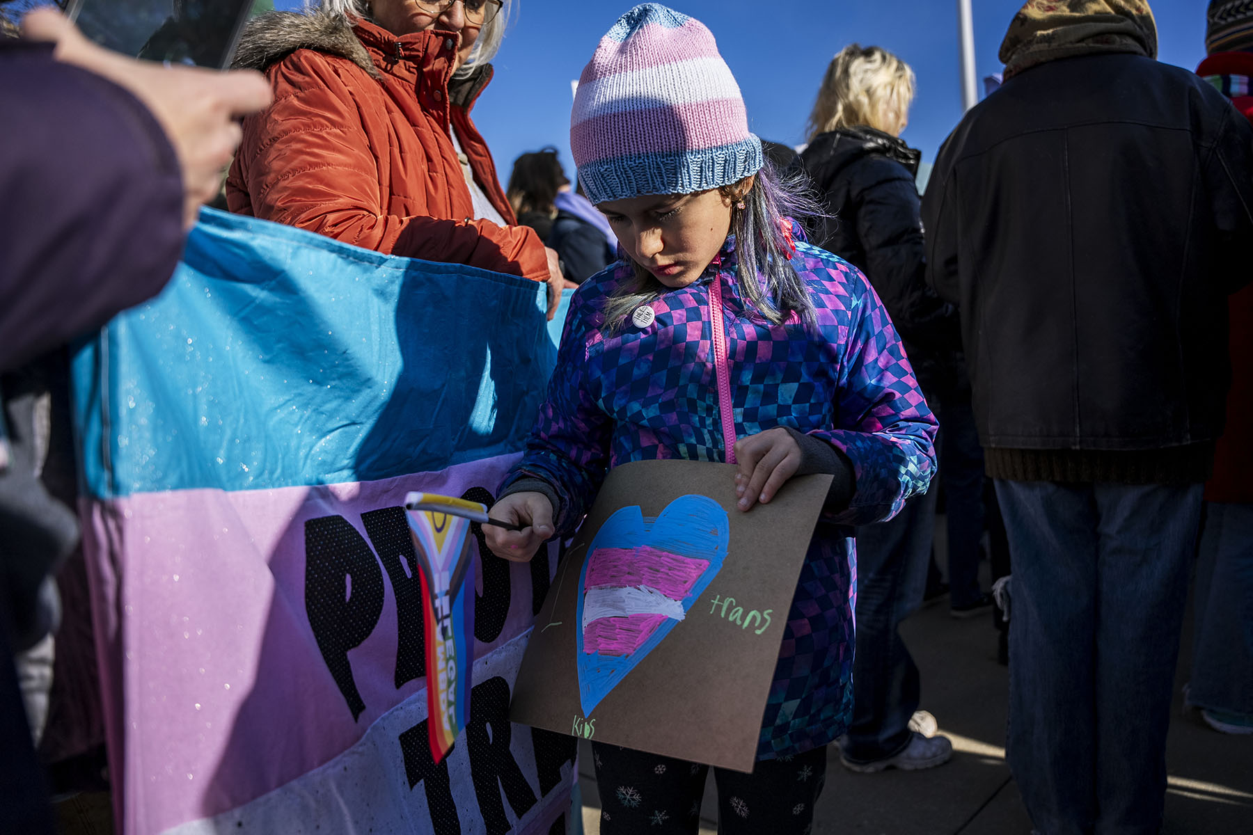 A non-binary child attends a protest outside the Supreme Court during the United States v. Skrmetti arguments.