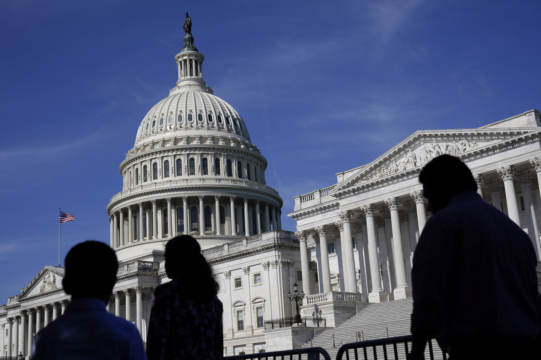 Silhouetted figures walk past the U.S. Congress building.