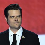 A closeup portrait of Matt Gaetz against a red backdrop.