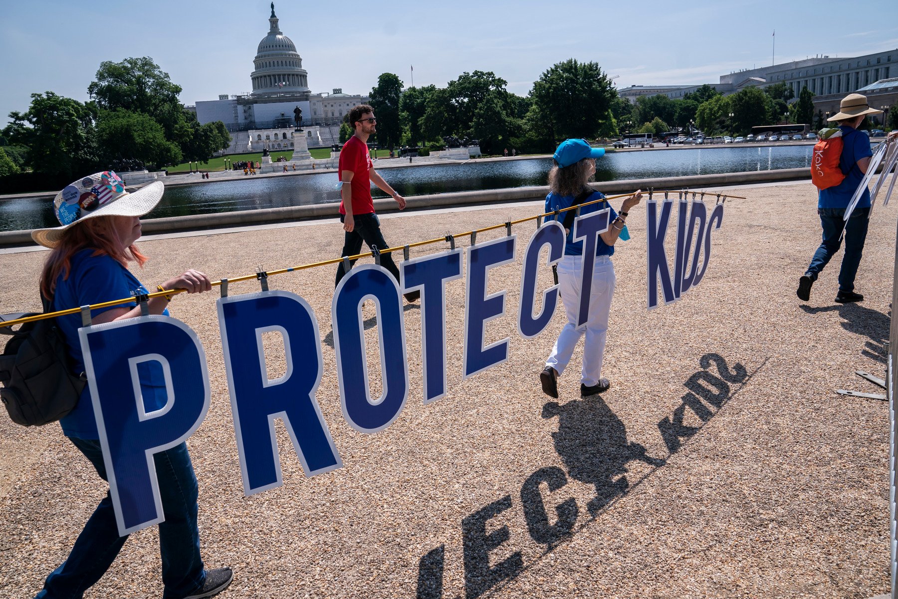 Deelnemers aan de rally dragen een bord langs het Amerikaanse Capitool met de tekst: "Bescherm kinderen".