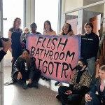 Protesters with Gender Liberation Movement, including Chelsea Manning (far right) and Racquel Willis (bottom left) sit inside the congressional bathroom closest to House Speaker Mike Johnson’s office.