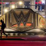 A person walks past a sculpture of a large WWE belt at WWE headquarters