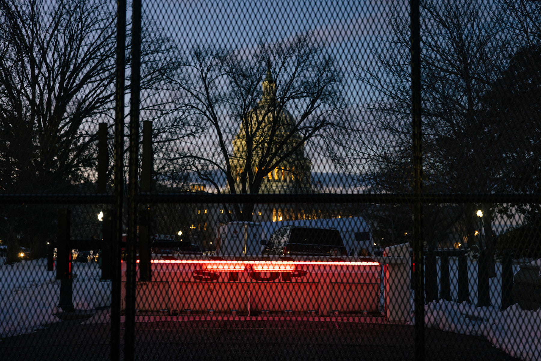 A barrier that reads "Stop" stands in front of Congress. Security fencing surrounds the U.S. Capitol and much of the National Mall ahead of Donald Trump’s second inauguration.