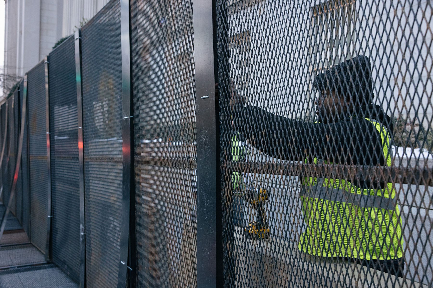 D’Wayne Glenn installs a segment of fencing near the White House ahead of Donald Trump’s second inauguration.