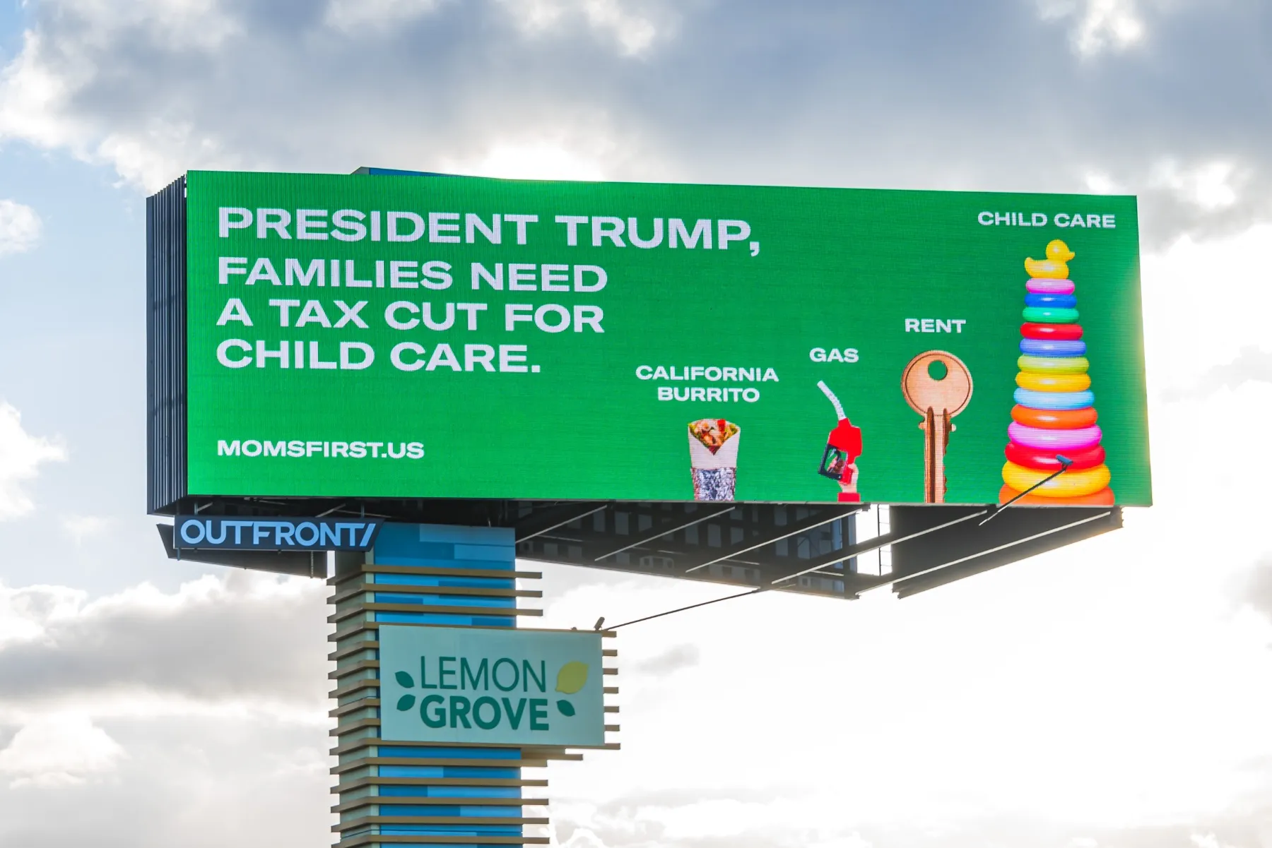 A billboard that reads: "President Trump, families need a tax cut for child care." with imagery of a burrito, gas pump, key and stack of child toys to demonstrate the cost of child care.