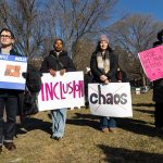 Young people stand together and hold signs the Boston Common.