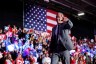 Robert F. Kennedy Jr. on stage with an American flag behind him.