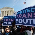 Protesters hold signs in front of the Supreme Court that read 