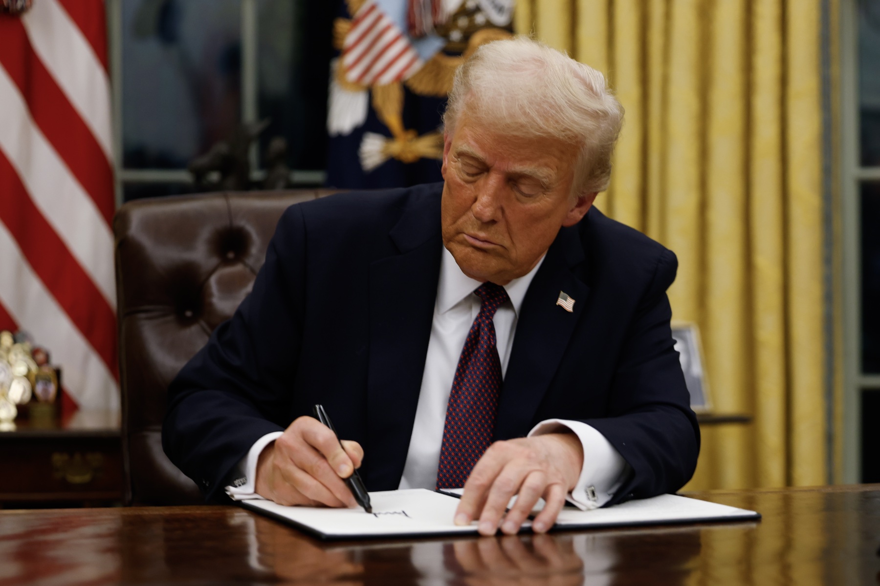 President Donald Trump signs executive orders in the Oval Office of the White House on January 20, 2025 in Washington, DC. Trump takes office for his second term as the 47th president of the United States.