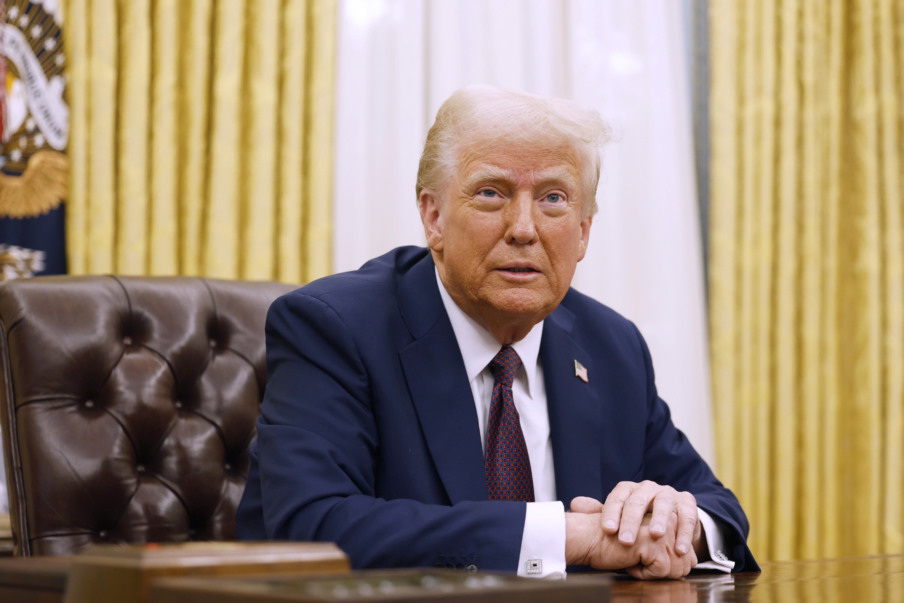 U.S. President Donald Trump speaks to reporters after signing a series of executive orders in the Oval Office of the White House.