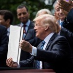 President Trump signs an executive order in the Rose Garden of the White House.