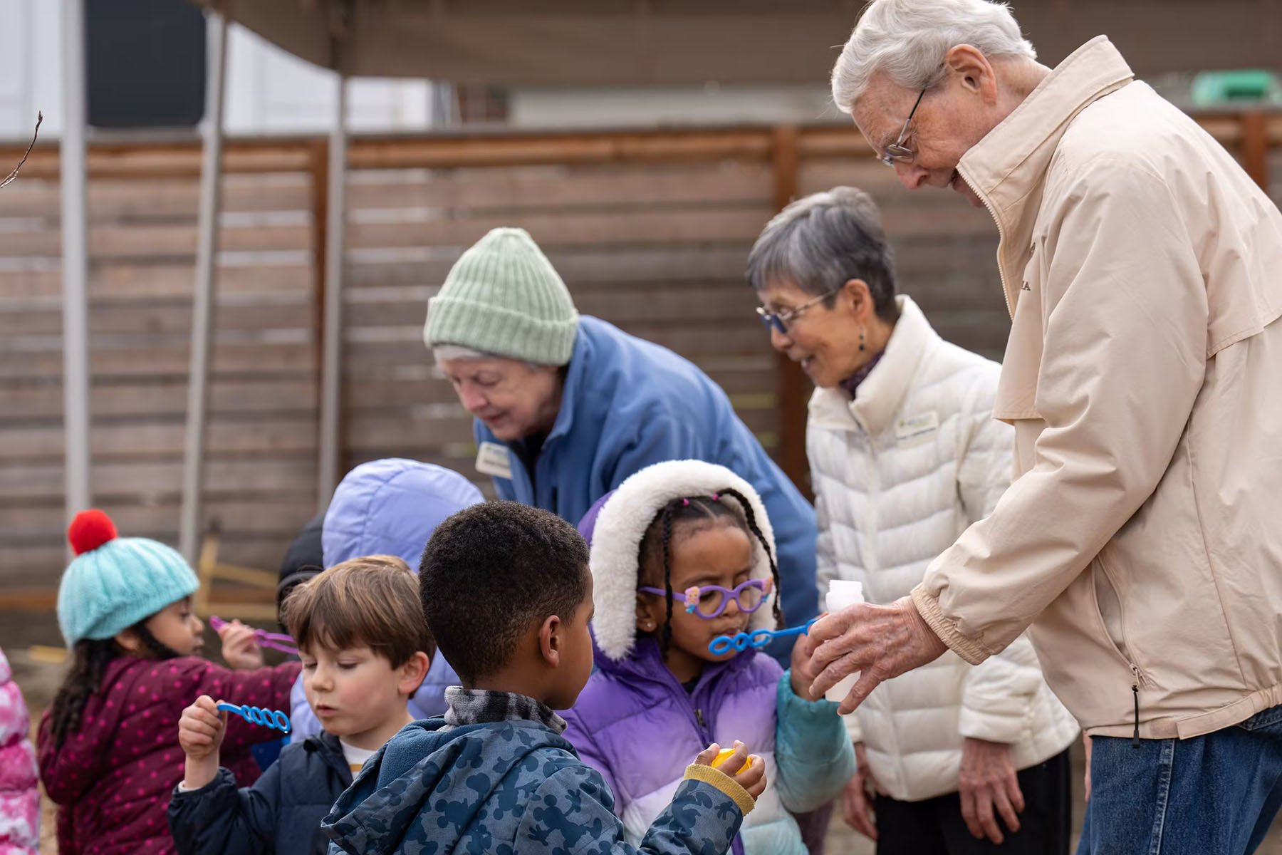 Wesley Homes residents enjoy blowing bubbles with Bezos Academy preschool students.