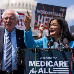 Sen. Bernie Sanders looks on as Rep. Pramila Jayapal speaks during a news conference to announce the re-introduction of the Medicare For All Act of 2023.