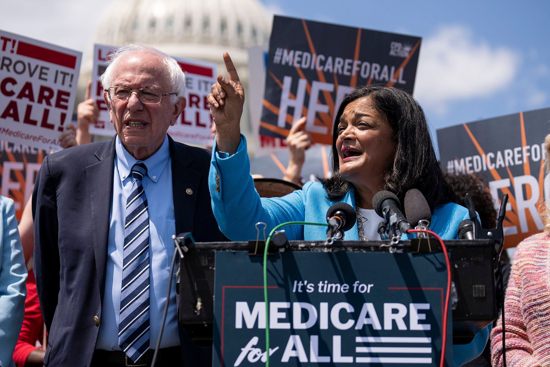 Sen. Bernie Sanders looks on as Rep. Pramila Jayapal speaks during a news conference to announce the re-introduction of the Medicare For All Act of 2023.