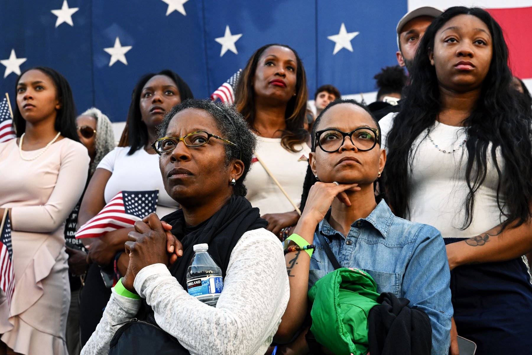 Women listen as Vice President Kamala Harris concedes the election during a speech at Howard University.