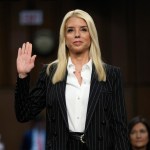 A standing woman raises her hand to be sworn in.