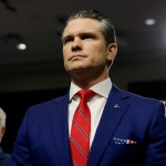 Pete Hegseth stands at his confirmation hearing.