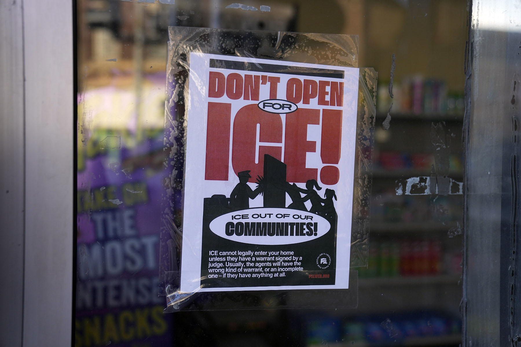 A sign regarding the Immigration and Customs Enforcement is posted on the window of a corner store on the day of President Trump's Inauguration on January 20, 2025.