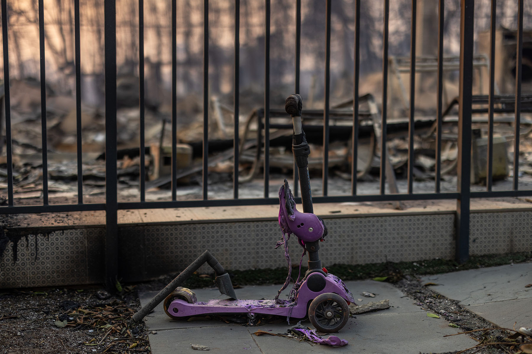 A child's scooter is melted in front of a home destroyed in the Palisades Fire in the Pacific Palisades community of Los Angeles.