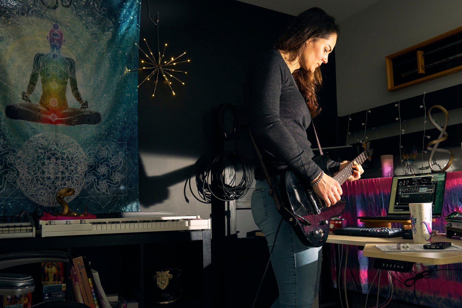 A woman plays guitar surrounded by musical instruments.