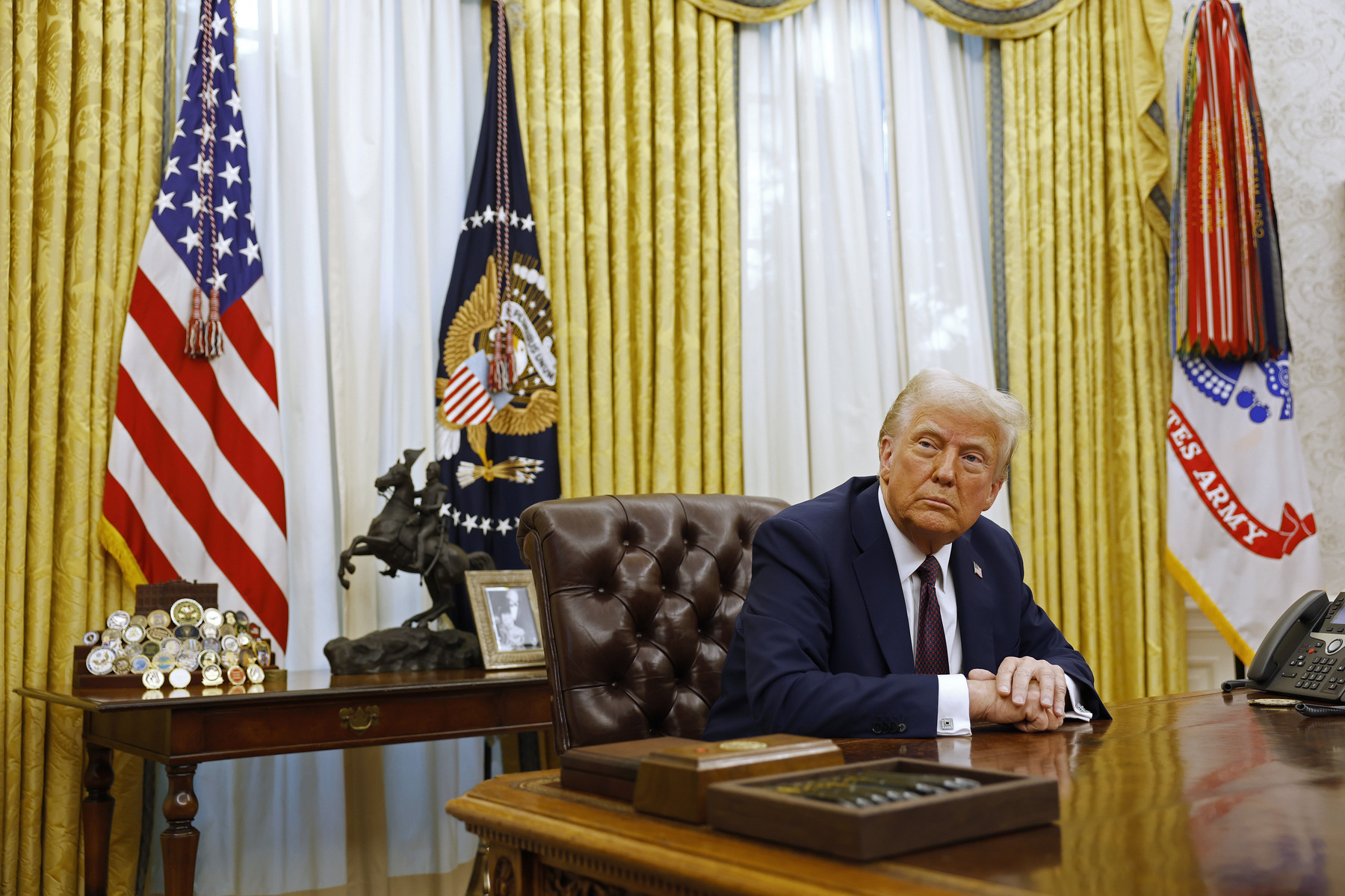 U.S. President Donald Trump sits at his desk in the Oval Office.