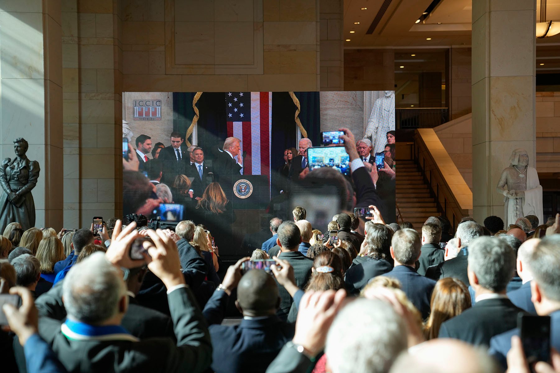 Guests and supporters are seen in an overflow room as they watch Donald Trump being sworn in during his Inauguration ceremony.