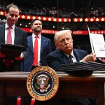 President Trump holds an executive order he just signed during the inaugural parade inside Capital One Arena.