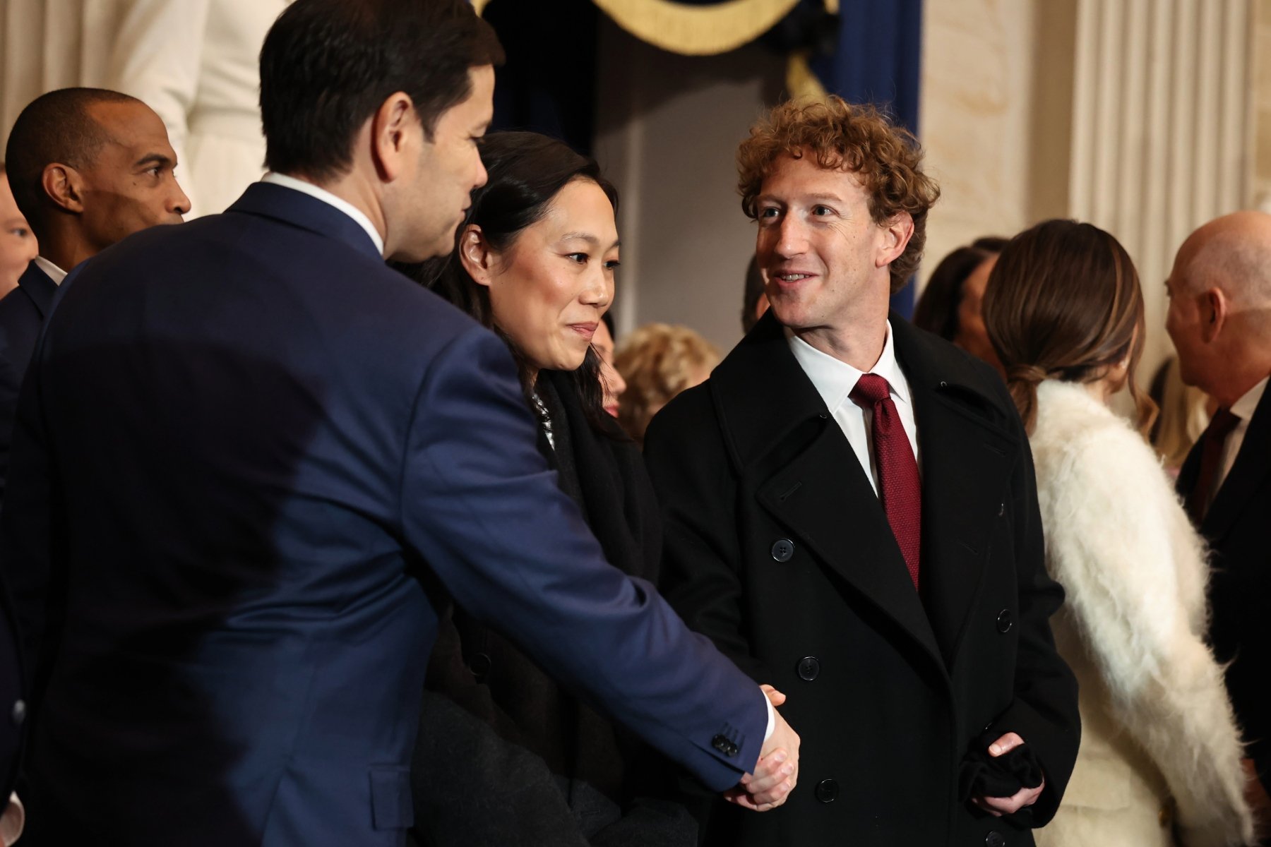 Two men shake hands.